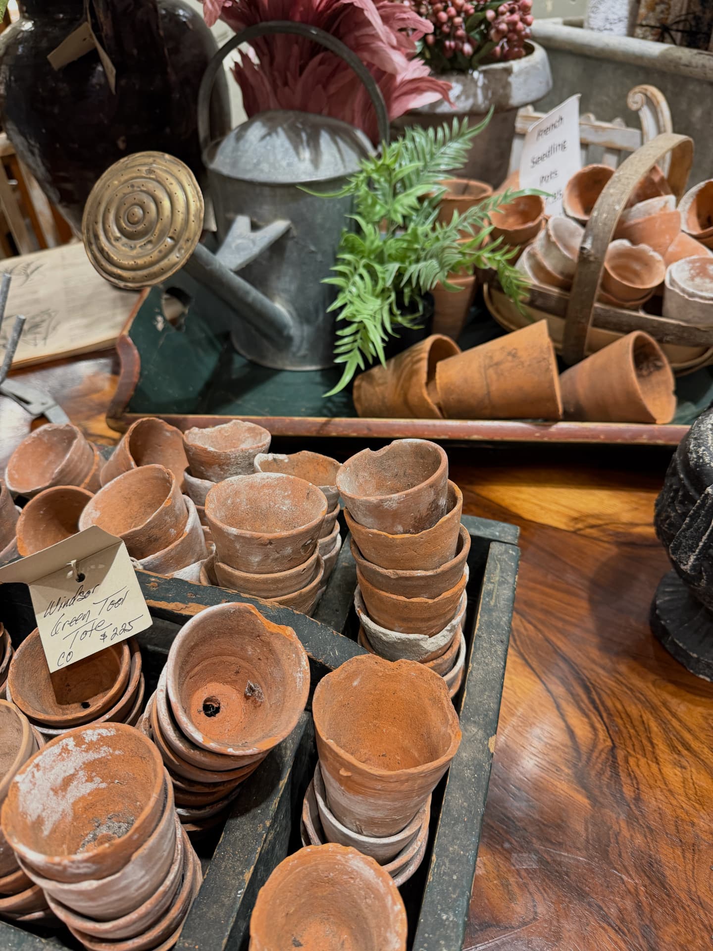 Terracotta pots and vintage garden tools arranged on a wooden table
